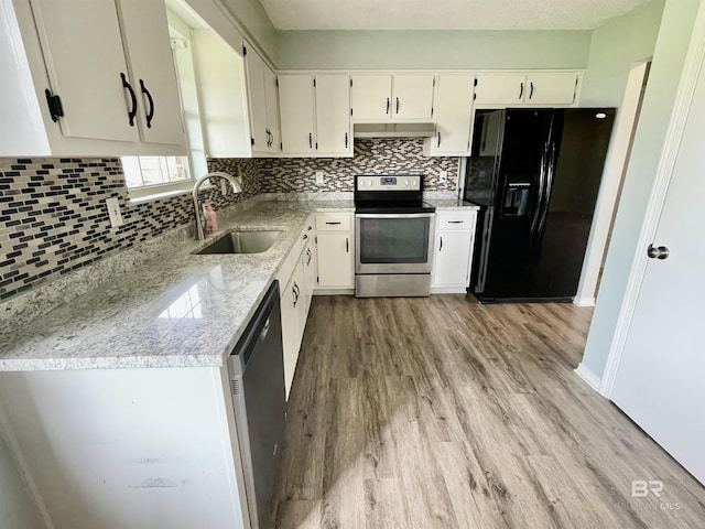 kitchen with appliances with stainless steel finishes, light stone countertops, sink, and white cabinets