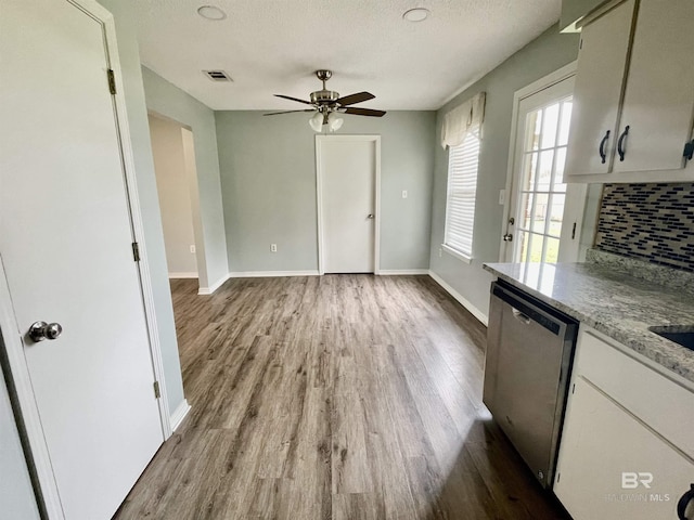 kitchen featuring hardwood / wood-style flooring, dishwasher, decorative backsplash, and white cabinets