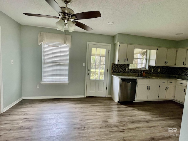 kitchen with white cabinetry, dishwasher, sink, decorative backsplash, and light hardwood / wood-style floors