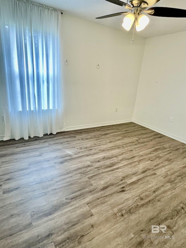 spare room featuring hardwood / wood-style flooring and ceiling fan