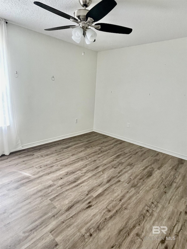 unfurnished room featuring hardwood / wood-style flooring, ceiling fan, and a textured ceiling