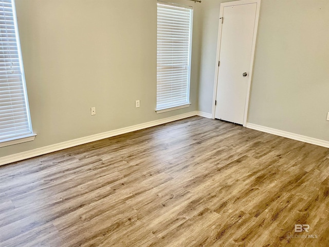 unfurnished room featuring a healthy amount of sunlight and light hardwood / wood-style floors