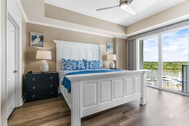 bedroom featuring a water view, access to exterior, ornamental molding, and dark wood-style flooring