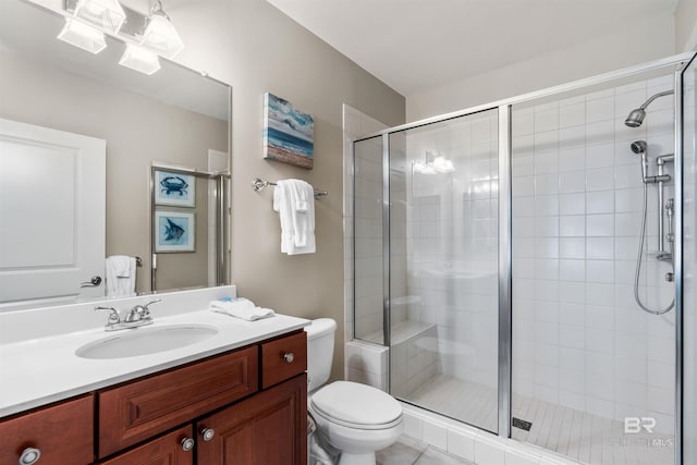 bathroom with toilet, a shower stall, and vanity