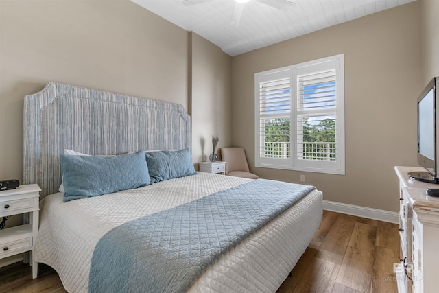 bedroom featuring dark wood-style flooring, a ceiling fan, and baseboards