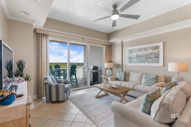 living area with light tile patterned floors, baseboards, a ceiling fan, and crown molding