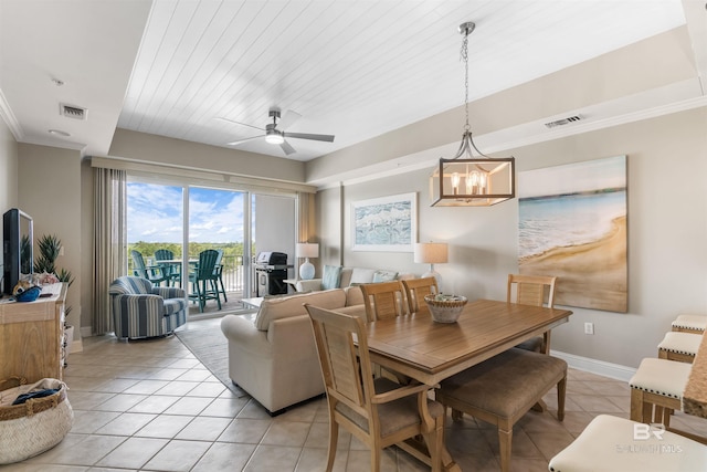 dining area featuring crown molding, light tile patterned floors, visible vents, baseboards, and ceiling fan with notable chandelier