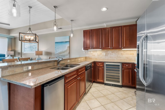 kitchen with wine cooler, pendant lighting, appliances with stainless steel finishes, a sink, and a peninsula
