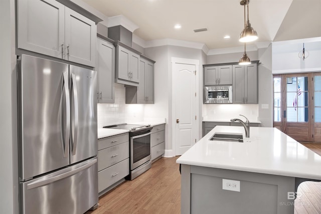 kitchen featuring stainless steel appliances, gray cabinets, hanging light fixtures, and sink