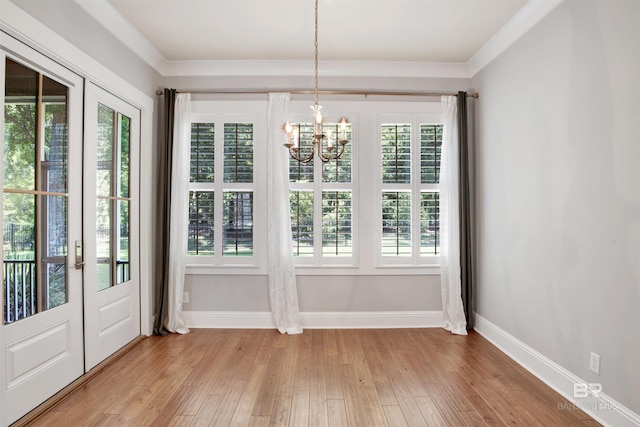 unfurnished dining area featuring a notable chandelier, light hardwood / wood-style floors, a wealth of natural light, and french doors