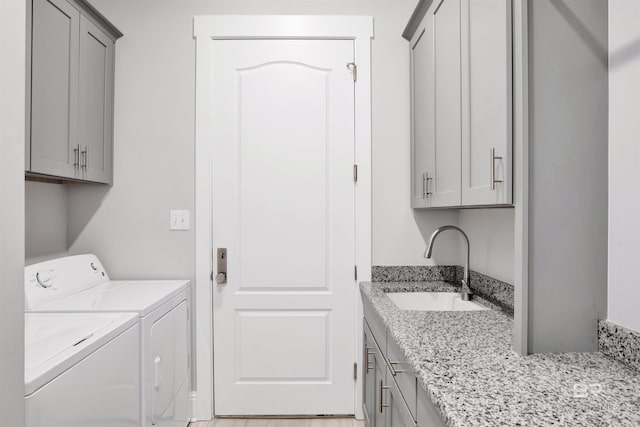 laundry area with washer and dryer, cabinets, and sink