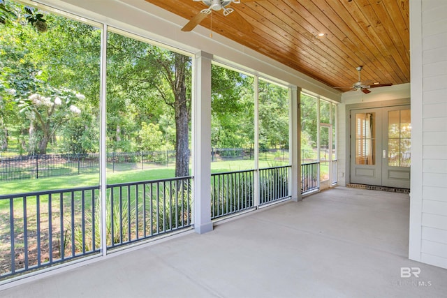 unfurnished sunroom featuring a healthy amount of sunlight, french doors, and wood ceiling