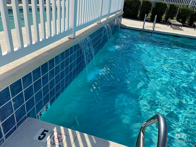 view of swimming pool with pool water feature