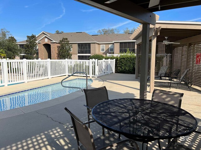 view of swimming pool with ceiling fan and a patio area