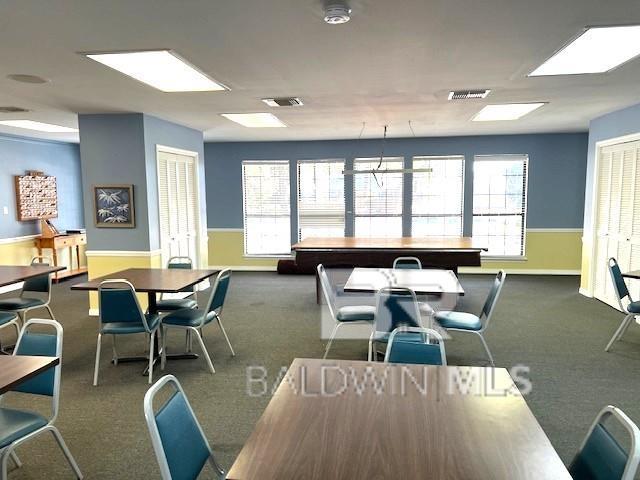 carpeted dining area featuring visible vents and baseboards