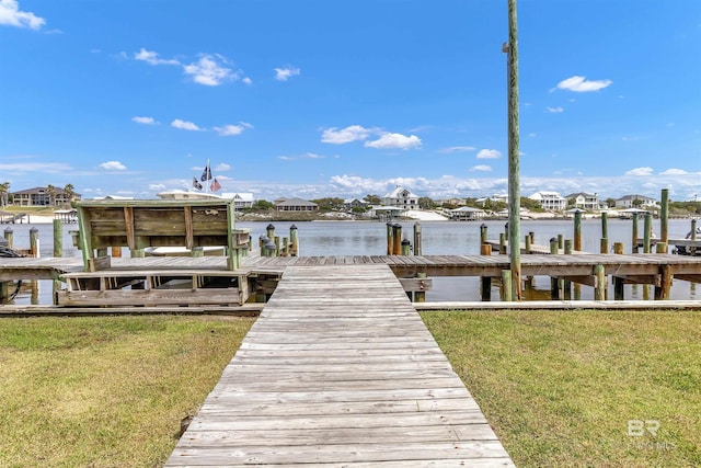 view of dock featuring a lawn and a water view