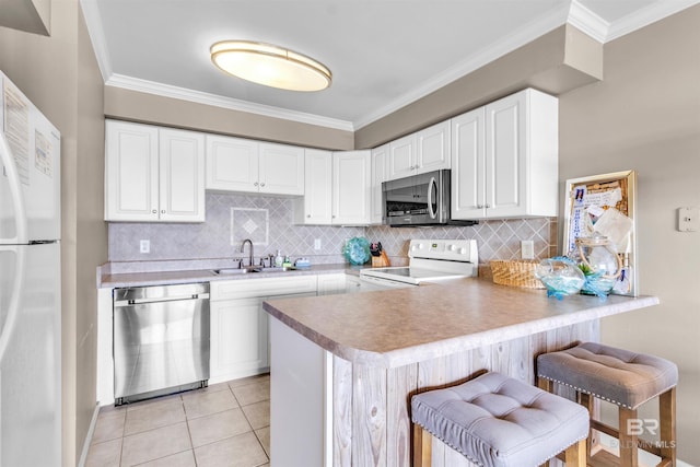 kitchen featuring ornamental molding, a sink, a peninsula, and stainless steel appliances