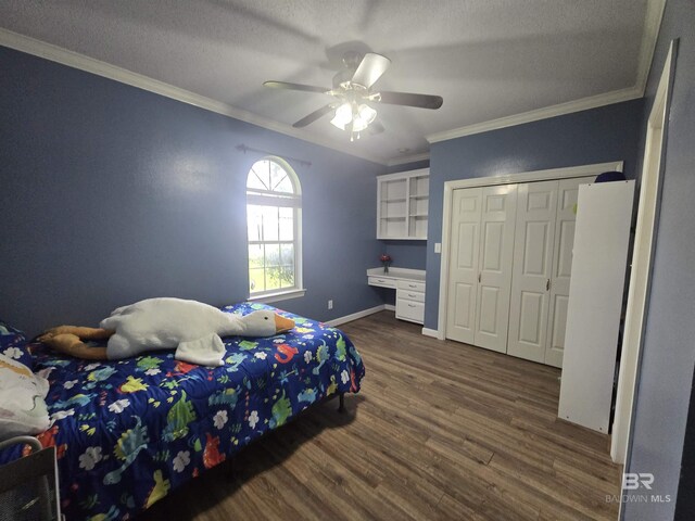 bedroom with a closet, dark wood-type flooring, a ceiling fan, baseboards, and ornamental molding