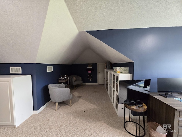 home office with carpet flooring, a textured ceiling, visible vents, and vaulted ceiling