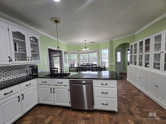 kitchen with dark countertops, brick floor, and a peninsula