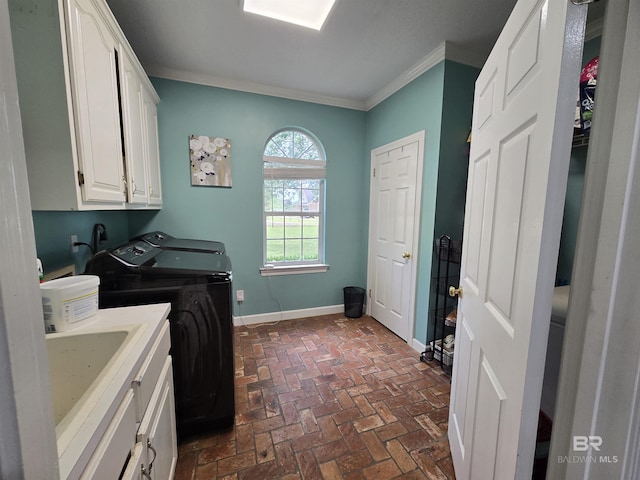 laundry area with brick floor, washing machine and clothes dryer, cabinet space, baseboards, and crown molding