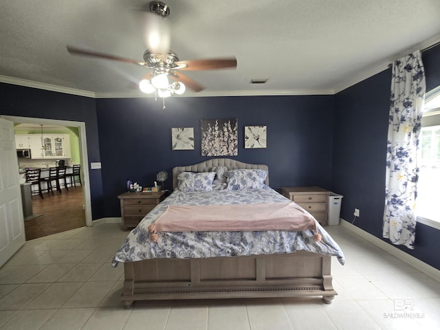 tiled bedroom with crown molding, a ceiling fan, visible vents, baseboards, and a textured ceiling