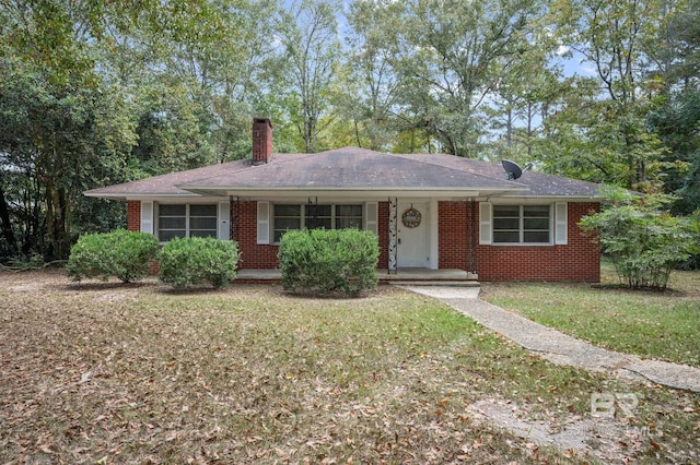 ranch-style home with covered porch and a front lawn