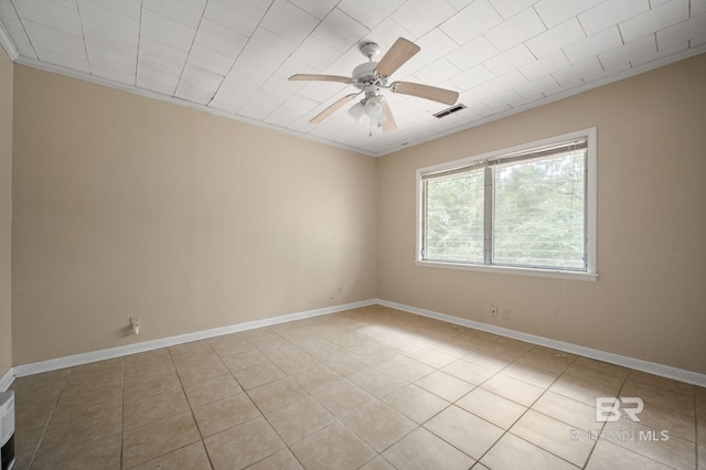 tiled spare room featuring ceiling fan and ornamental molding