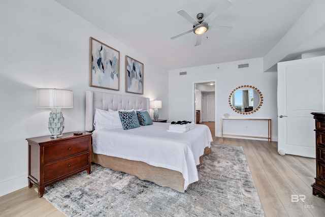 bedroom featuring visible vents, ceiling fan, baseboards, and wood finished floors