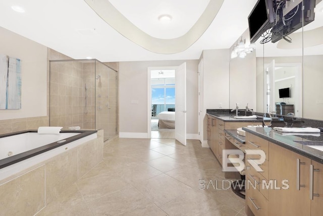 ensuite bathroom with ensuite bathroom, a garden tub, vanity, and a shower stall