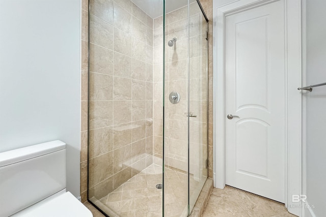 bathroom featuring toilet and a shower stall