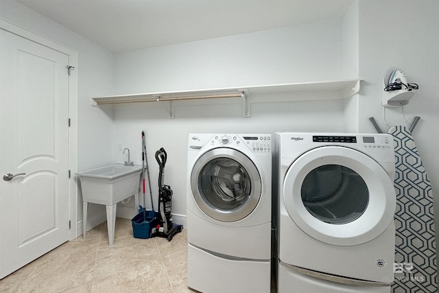 laundry room featuring light tile patterned floors, laundry area, and washer and clothes dryer