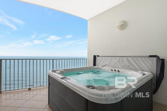 balcony with a water view and a hot tub