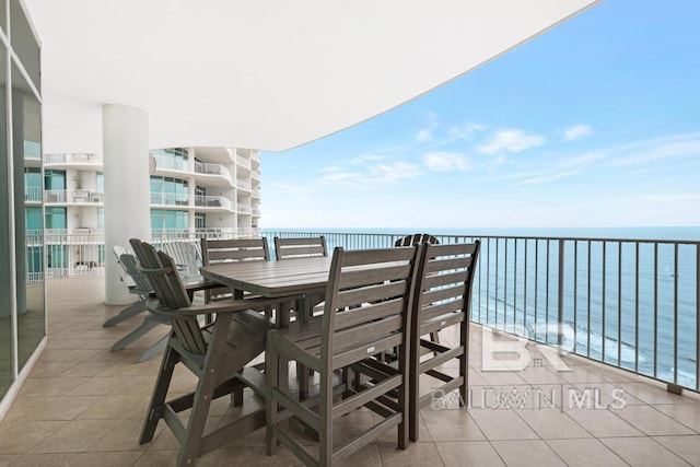 balcony with a water view and outdoor dining space