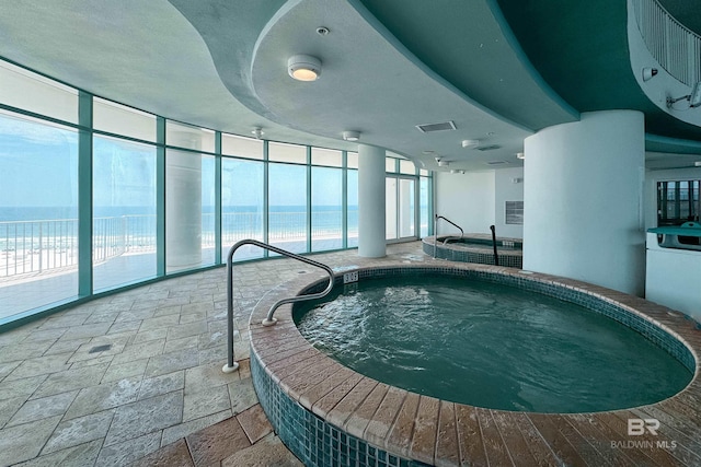 view of pool with a water view and an indoor hot tub