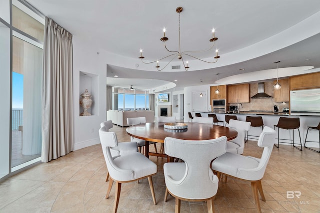 dining area with baseboards, visible vents, a tray ceiling, recessed lighting, and a notable chandelier