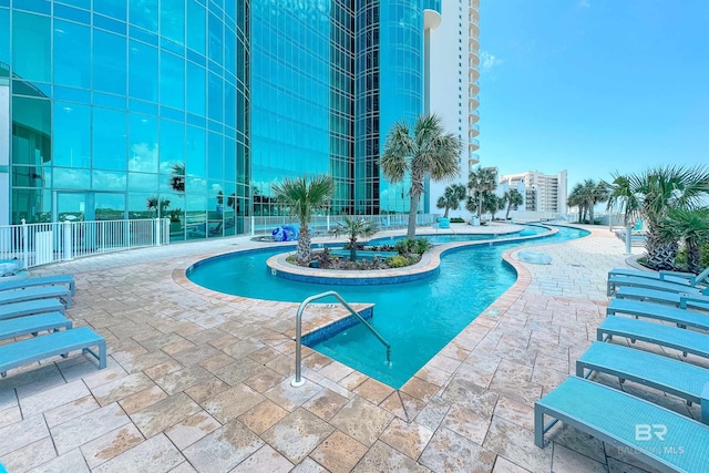 community pool with a patio and fence