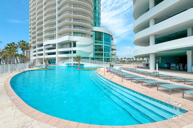 pool with a patio and fence