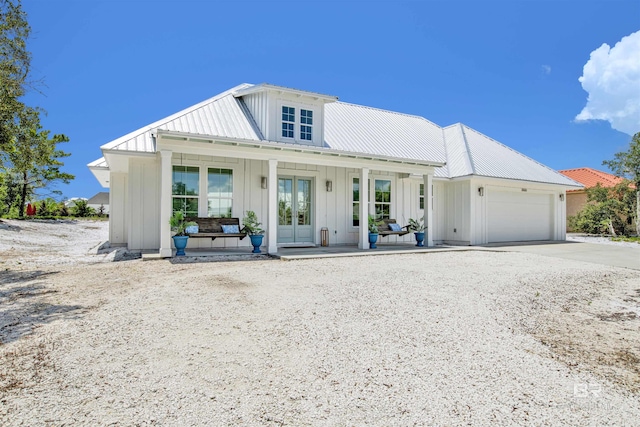 view of front of house featuring french doors, a garage, and a porch