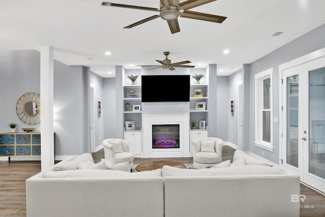 living room with ceiling fan, dark hardwood / wood-style flooring, and built in features