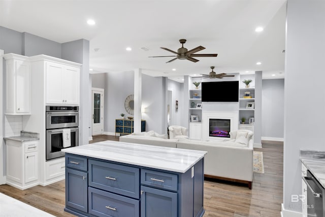 kitchen featuring white cabinets, blue cabinetry, and double oven