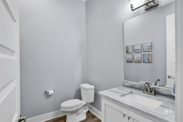 bathroom with vanity, hardwood / wood-style flooring, and toilet