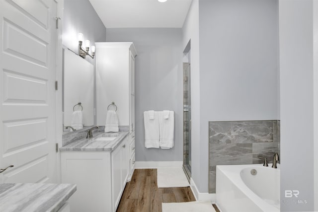 bathroom featuring vanity, hardwood / wood-style floors, plus walk in shower, and a notable chandelier