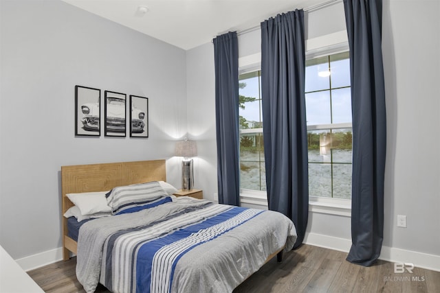 bedroom with dark hardwood / wood-style flooring