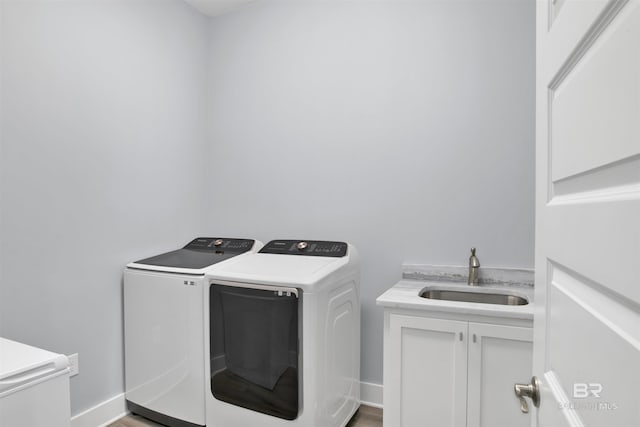 washroom featuring washer and clothes dryer, sink, and cabinets