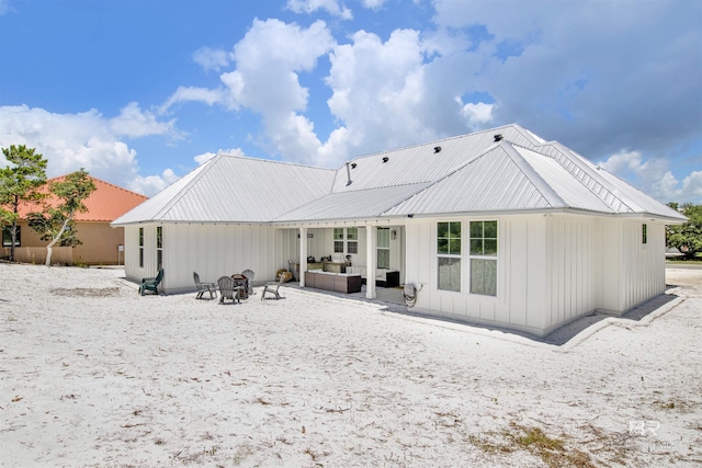 rear view of property with an outdoor living space and a patio area