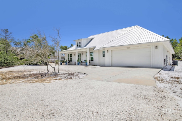 view of front of home featuring a porch, a garage, and central air condition unit