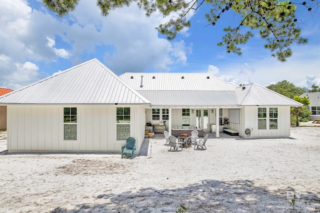 back of house with an outdoor living space with a fire pit and a patio