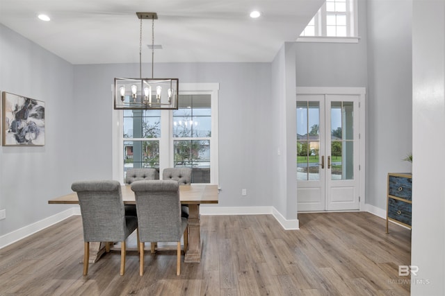 dining space featuring hardwood / wood-style flooring, an inviting chandelier, and french doors