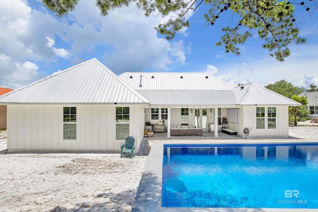 rear view of property with an outdoor living space and a patio